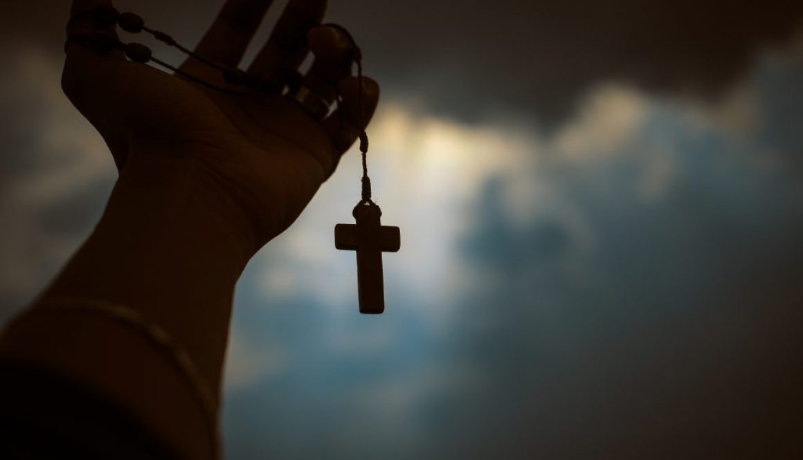 person-holding-brown-wooden-cross-4068583