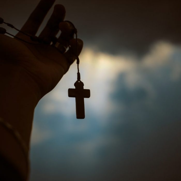 person-holding-brown-wooden-cross-4068583